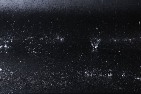 水滴落在黑色的背景上.雨天照片