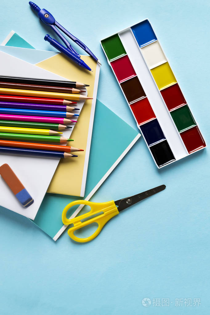 从笔记本，圆规，铅笔，剪刀，油漆和一个橡皮擦在蓝色背景和复印空间的配件。平铺