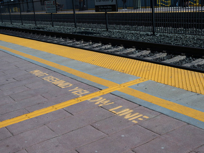 列车站台地面黄色警戒线后等候图片