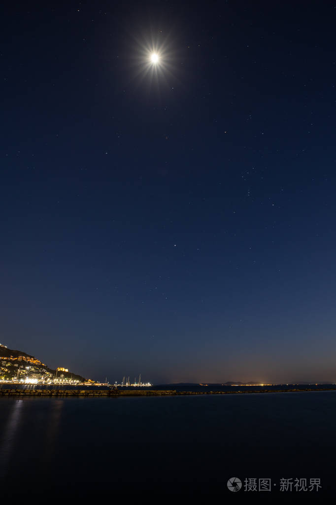 夜幕中月亮和星星在海面上闪耀
