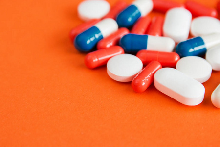 橙色背景上分离的彩色胶囊,文本的复制空间,选择性聚焦,俯视.
