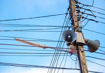 云和蓝天下的电线杆和电缆照片