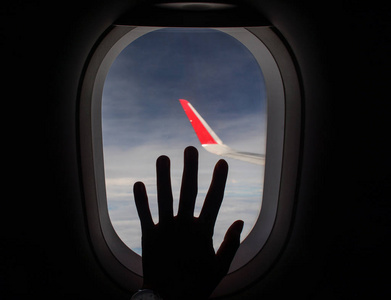 伸过一只手从飞机的窗户上伸过去照片
