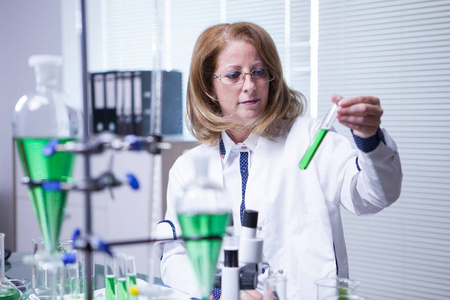 穿着白大褂从事学术研究的女生物学家照片