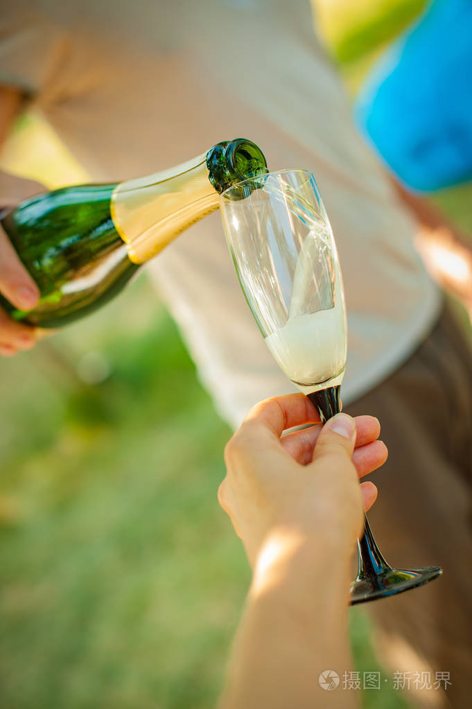 特写手边在玻璃杯里倒香槟