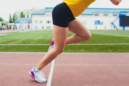 女选手在阳光明媚的情况下从起跑线上开始冲刺.照片
