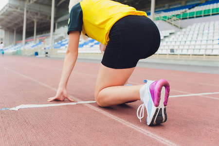 女选手在阳光明媚的情况下从起跑线上开始冲刺.照片