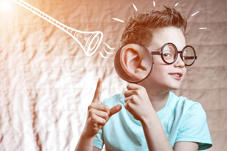 听力检查穿轻便t恤的男孩通过管子检查听力照片