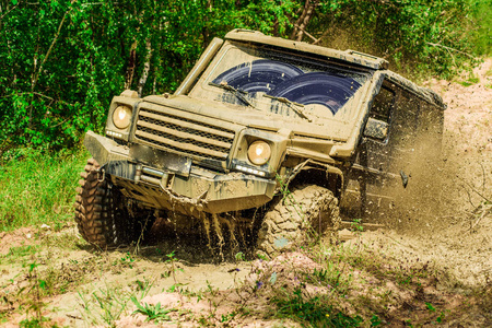 泥泞山路在乡村道路和山区背景上的大型越野车车轮的俯视图.