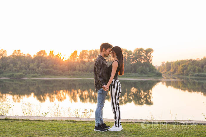 关系爱情和自然概念迷人的女人和英俊的男人在水上拥抱和亲吻