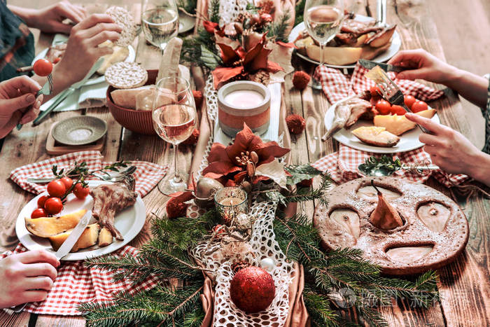 平躺在一起吃饭喝酒的朋友的手人们在木制的乡村餐桌上聚会聚会庆祝的