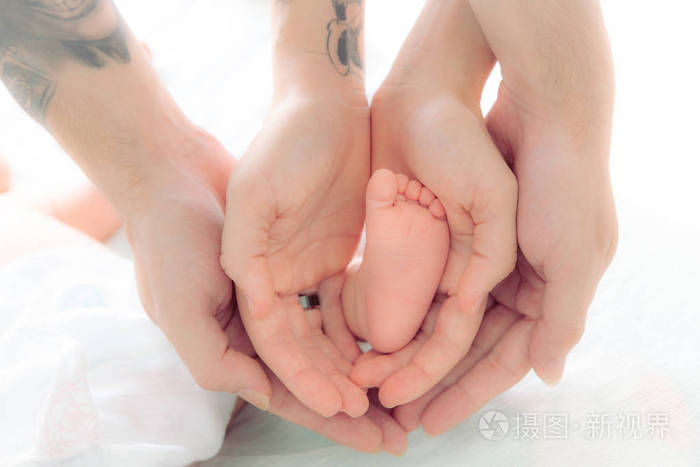 新生儿的一只脚在父母手里