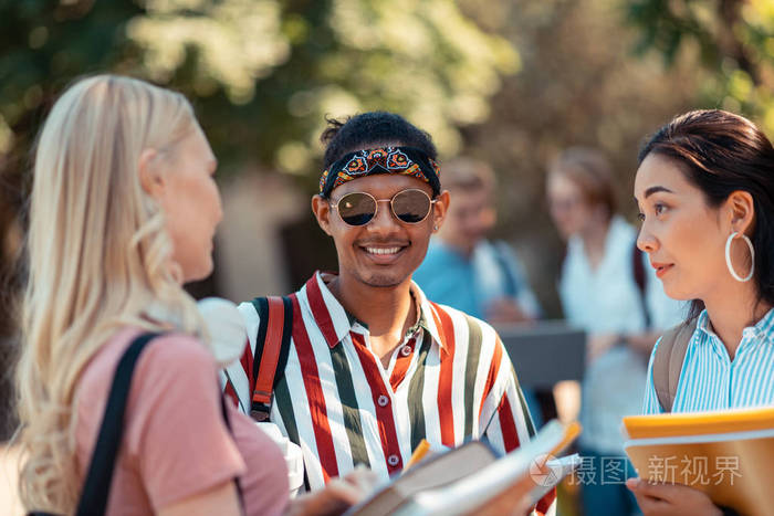 兴高采烈的男孩站在会说话的同伴中间