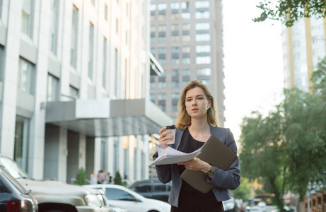 上班忙碌忙碌的女上班族拿着咖啡笔记本电脑文件照片