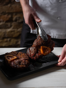 烤的 男人 烧烤 烹饪 脂肪 火钳 美味的 牛排 牛腰肉照片