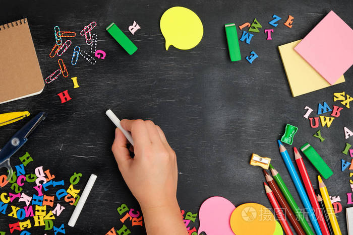 女性用白色粉笔在黑板上写字