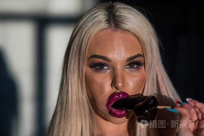 嘴唇性感的女人拿着棒棒糖金发美女给大人吸棒棒糖