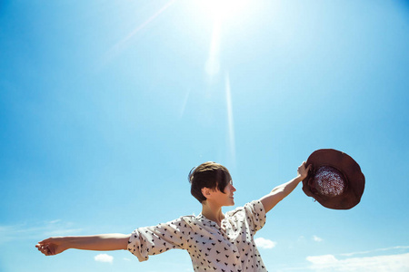 戴帽子的年轻女子享受夏日时光举起双手旅行生活方式快乐情感户外度假