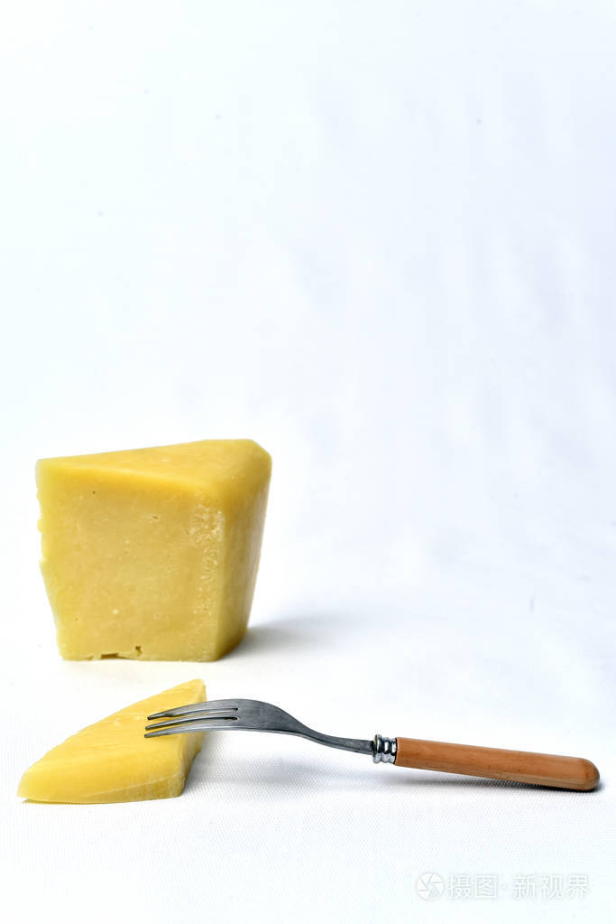 桌子上白色背景上的一块奶酪
