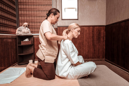 在美容spa享受肩部按摩的女性男子猪鬃严重面部肌肉肩部, 城市背景