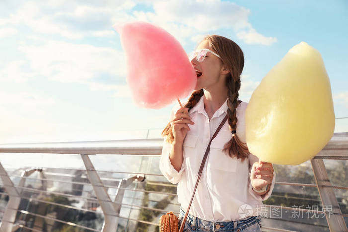 阳光明媚的日子里一个拿着棉花糖的年轻女人文本空间