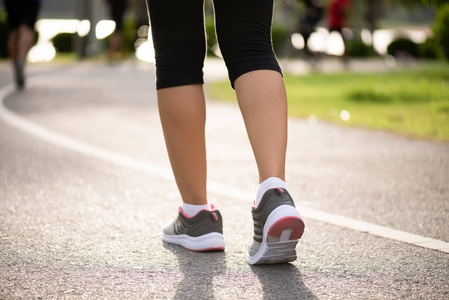 年轻的健身女运动员在公园里感到膝盖疼痛户外运动概念