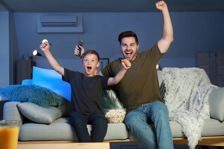 父亲和儿子在家看电视体育节目图片