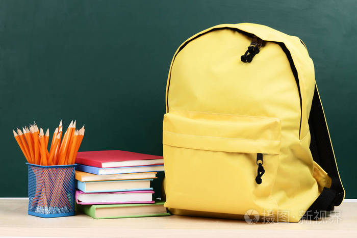 绿色背景的书包和铅笔