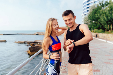 兴高采烈的男女运动员在跑步后检查时间照片