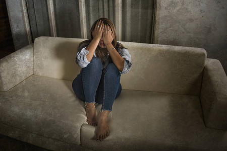 里绝望地哭泣沙发上感到心碎遭受抑郁危机和焦虑问题笼罩着她的脸照片