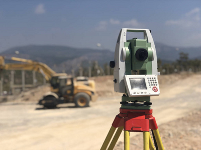 精度地图背景模糊的施工现场全站仪照片