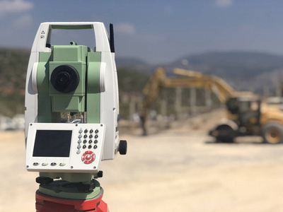 精度地图背景模糊的施工现场全站仪照片