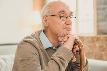 秃头老人干净利落的半秃头老人,若有所思地靠着木棍照片