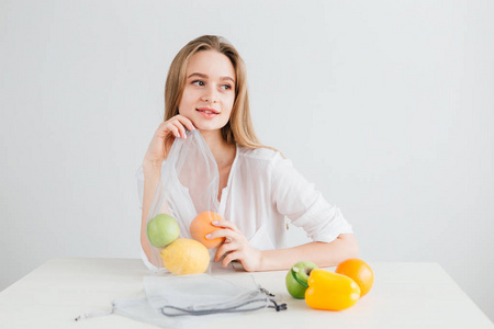 装蔬菜的袋子女孩把蔬菜和水果装在可重复使用的布袋里照片