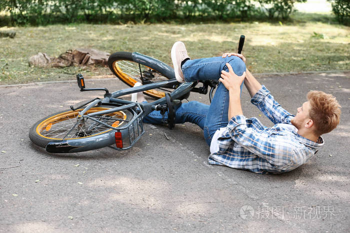 年轻人在户外从自行车上摔下来