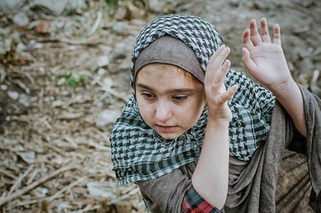 救援女孩一个在战争中的难民儿童,一个满脸脏兮兮的穆斯林女孩站在