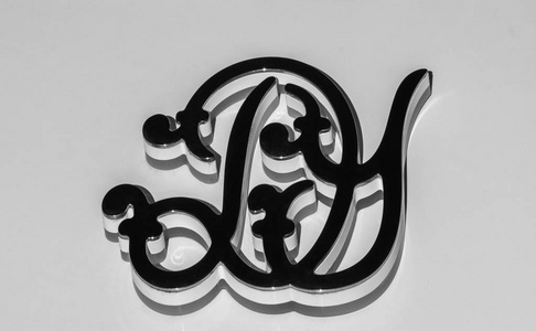 字体水印字母d和y在一个凸起的钢花押字上,孤立在白色背景上照片