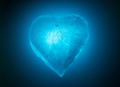 冰封的心象征蓝色特写镜头在蓝色冷光中发光.有气泡的冰的质地.照片