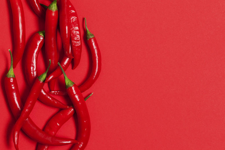 红辣椒排列在鲜红色的背景上图片