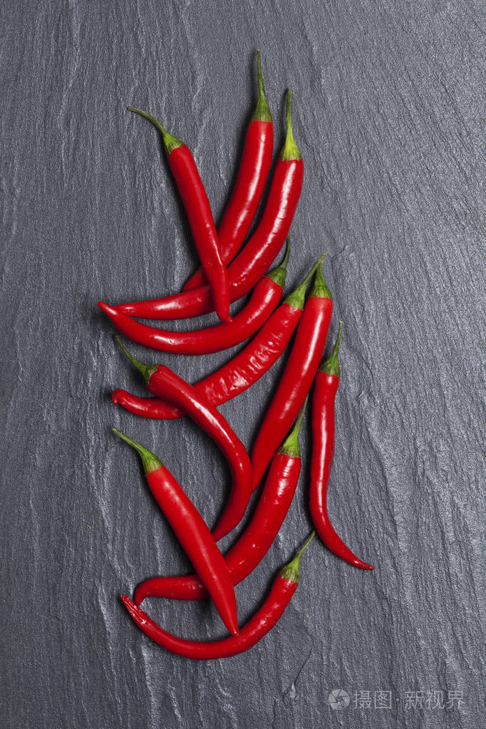 深色石板背景上的新鲜红辣椒