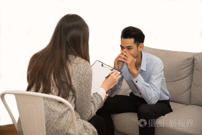亚洲男性和心理学家坐在沙发上