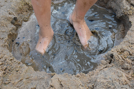 情绪活跃夏天男孩在河岸上玩泥巴.活跃儿童h照片