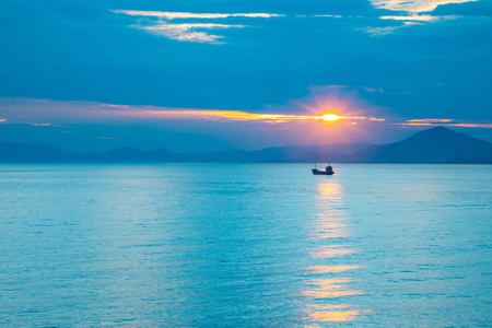 中国海南三亚,夕阳余晖中的海上渔船照片