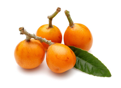 一堆成熟的枇杷果,叶白色照片