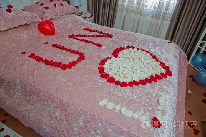 红色的花瓣和心形的气球.由花瓣组成的u和n字母.婚礼用的白色花束.