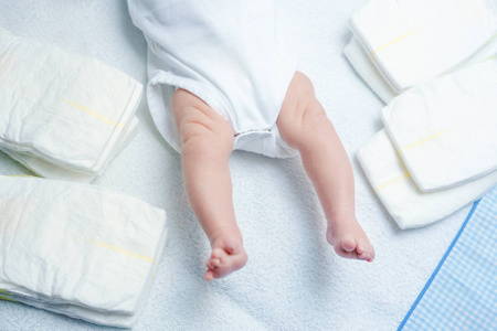 更换工作台新生儿的脚放在换尿布的桌子上.可爱的小女孩或男孩两周大.