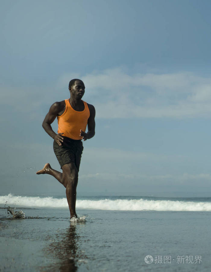 运动的全身肖像年轻迷人和健康的黑人美国黑人男子在海滩上跑步做夏季