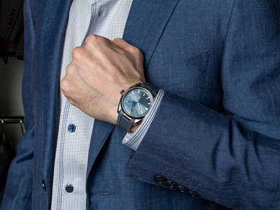 西装展示一个穿经典西装的男人展示一只昂贵的手表照片