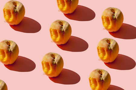 粉红色背景上有许多多汁的成熟桃子图案.创意布局照片