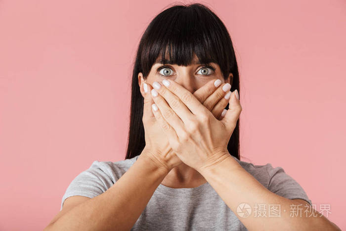 令人惊异的惊骇的女人在浅粉色背景墙上摆出孤立的姿势